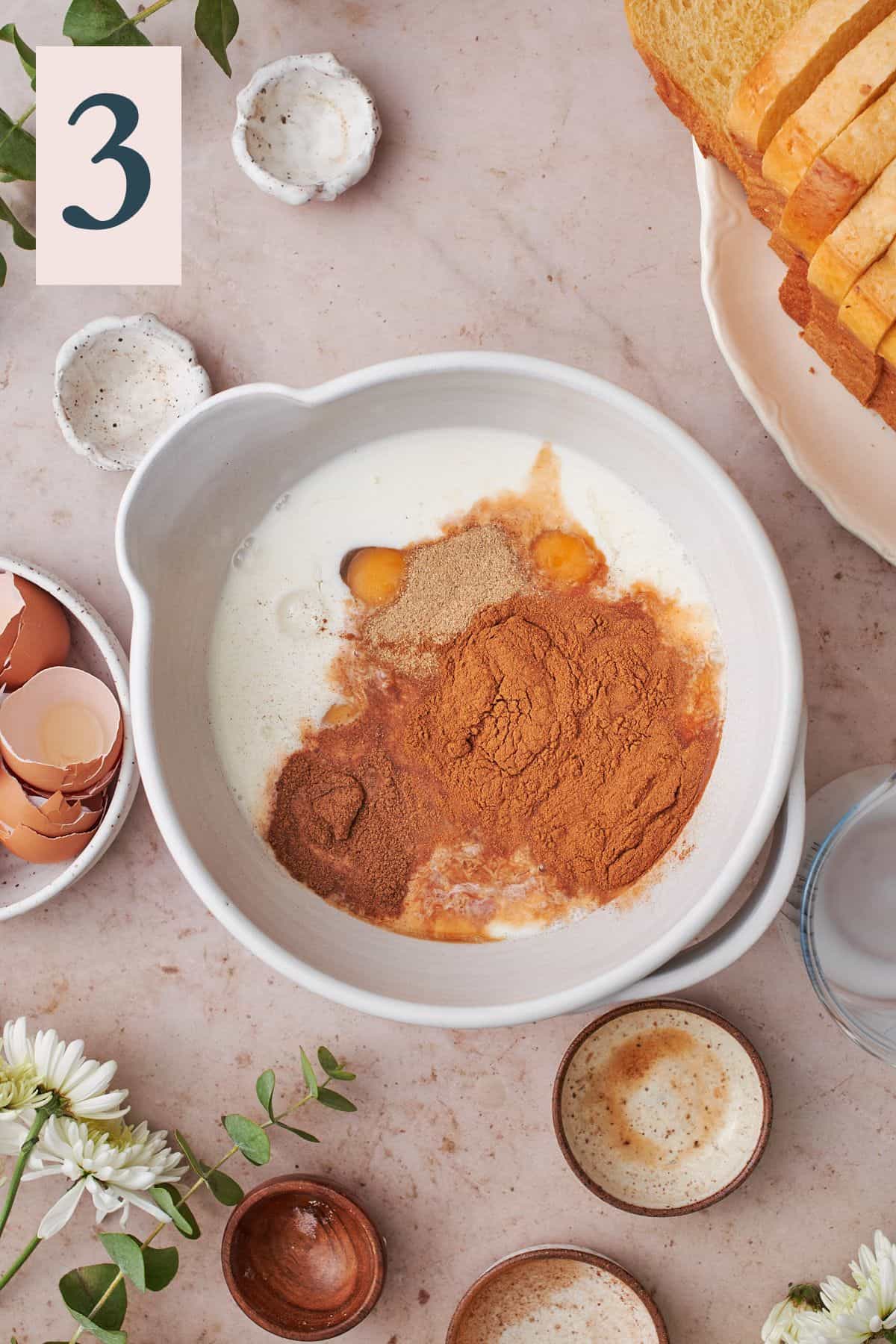 cinnamon and spices in a mixture of milk and eggs in a mixing bowl. 
