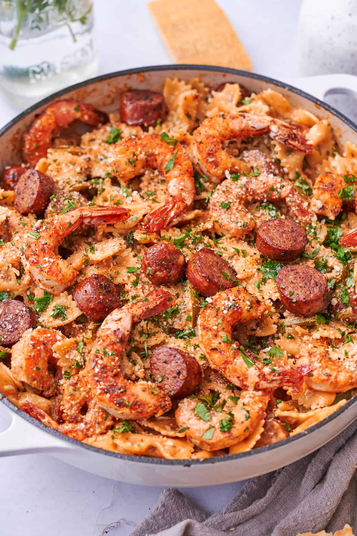 close up shot of cajun shrimp and sausage pasta in a large skillet. 